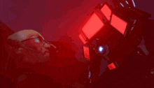 a man with glasses and a beard is looking at a robot