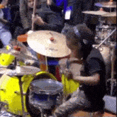 a man is playing a drum set in front of a crowd .