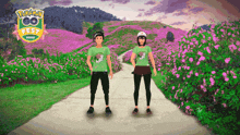 a man and a woman are standing on a path in front of a pokemon go fest sign