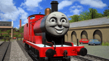 a red train with a smiling face is on a train track
