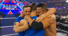 three men hugging each other in front of an all in texas sign