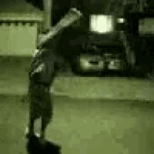 a person is doing a handstand on the ground in front of a car .
