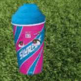 a pink and blue slurpee cup with a cartoon face on it