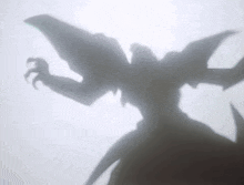 a shadow of a monster with wings and claws on a white surface .