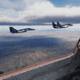 two fighter jets are flying over a desert