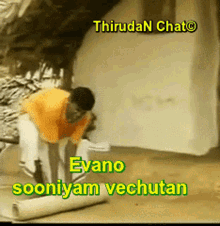 a man in an orange shirt is working on a piece of paper that says evano sooniyam vechutan on it