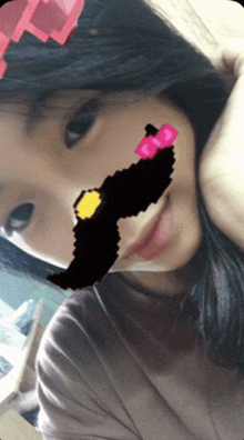 a girl with a drawing on her face that looks like a mustache