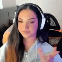 a woman wearing headphones is sitting in a chair in a room .