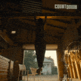 a man is doing a pull up in a garage with the word countdown on the ceiling