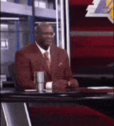 a man in a suit and tie is sitting at a desk
