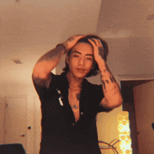 a man with tattoos on his arms and neck holds his head