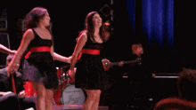 a group of women are dancing on a stage in front of marshall amps