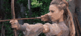 a woman in a purple dress is holding a bow and arrow in her hand