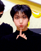 a close up of a person making a silly face with their finger in their mouth
