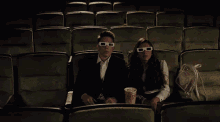 three people wearing 3d glasses are sitting in a theater