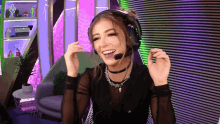 a woman wearing headphones and a microphone is smiling and making a funny face