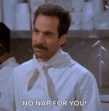 a man with a mustache is wearing a white shirt and tie .