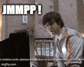 a man sitting in front of a computer with jmmpp written on the bottom right