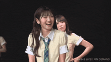 a girl giving a peace sign with the words akb48 live on demand below her