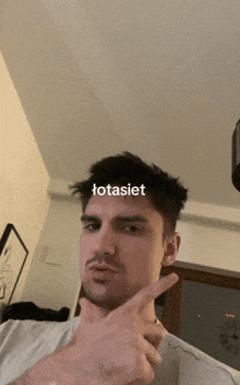 a man making a funny face with the word totasiet written on his face
