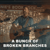 a bunch of broken branches is written above a man holding a guitar