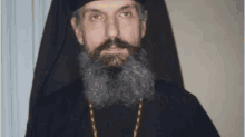 a man with a beard and mustache wearing a black robe