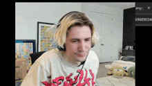 a man with blonde hair is wearing headphones and a t-shirt with flames on it