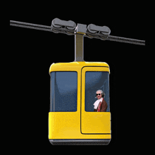 a man wearing headphones sits in a yellow gondola