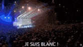 a man in a suit and tie speaking into a microphone with the words je suis blanc written below him