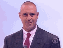 a man in a suit and tie is smiling and looking at the camera with a circle around his neck