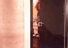 a woman with curly hair is standing in a doorway with the letter e on it