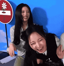 two girls are laughing in front of a sign that says no entry