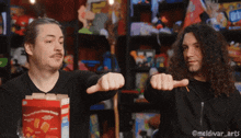 two men are pointing at a box of cheerios with their fingers
