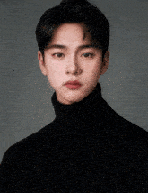 a young man wearing a black turtleneck sweater