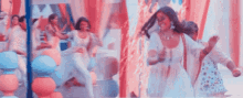 a woman in a white dress is dancing in front of a mirror .