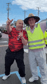 two men are posing for a picture and one of them is wearing a vest that says ' ucsd ' on it