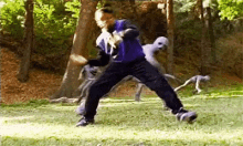 a man in a purple shirt is playing soccer in a field with a group of monsters behind him .