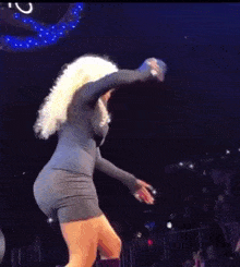 a woman in a gray dress is dancing on a stage .