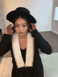 a woman is wearing a black hat and a white collar
