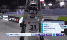 a skier wearing a number 34 jersey stands in the snow