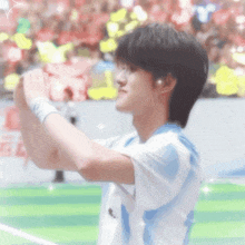 a young man wearing a blue and white shirt takes a picture of himself