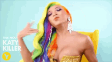 a woman with rainbow hair is sitting in a yellow chair with the words " talk about katy miller " above her