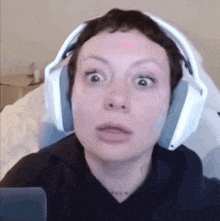 a woman wearing headphones is making a funny face while sitting in a chair .