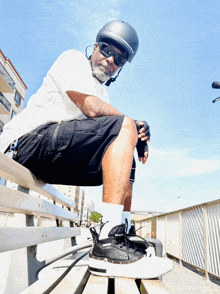 a man sitting on a bench wearing a helmet and sunglasses