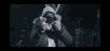 a group of people are standing in a dark room with smoke coming out of their mouths .