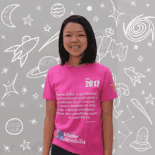 a girl wearing a pink shirt that says 2017 on it
