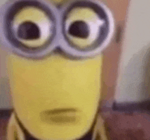 a close up of a minion wearing glasses and making a face .