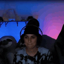 a woman wearing headphones is sitting in front of a stuffed animal .