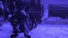 a person kneeling down in front of a car with a bmw logo on the back