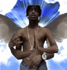 a shirtless man with angel wings and a necklace with the letter t on it